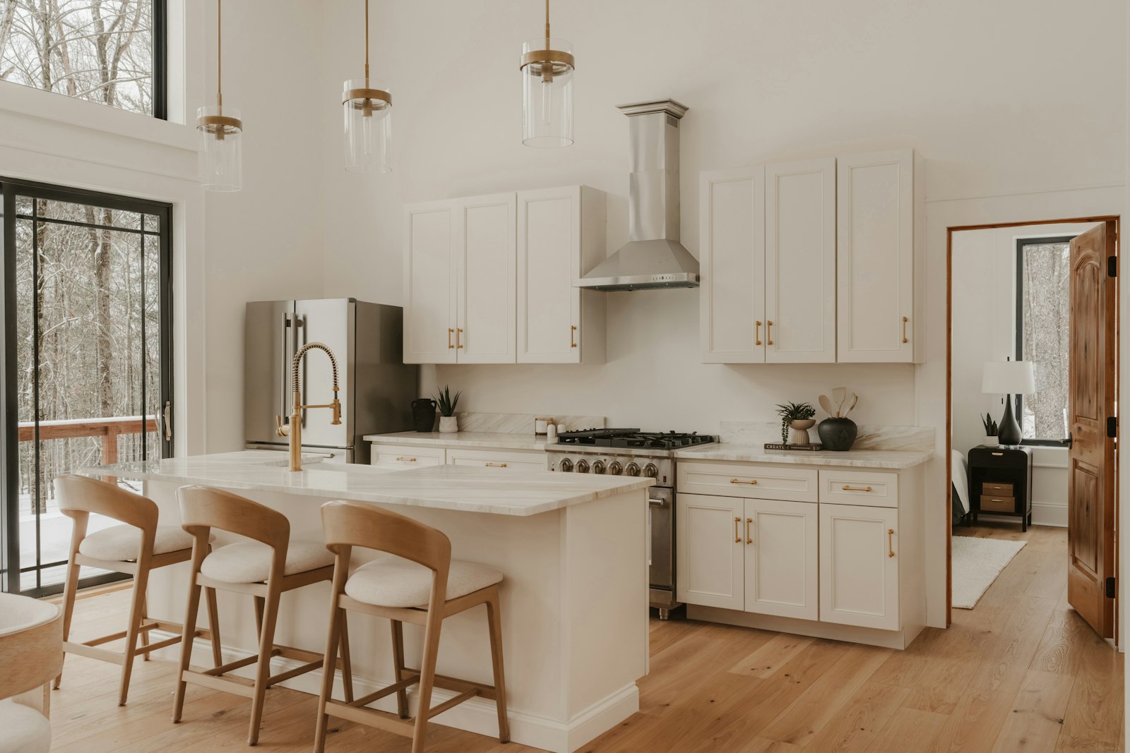 Bright kitchen with warm white cabinetry, a generous island and natural wood seating